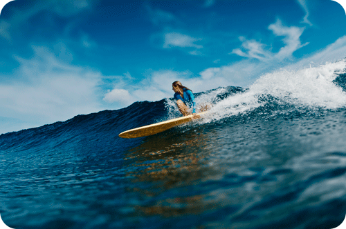 Chica surfeando en el mar.