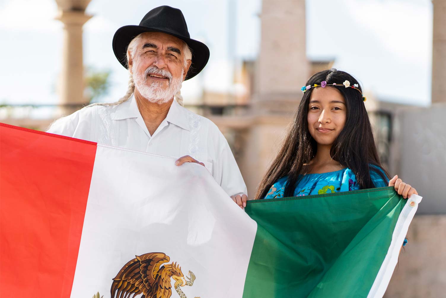 Un hombre y una niña sujetando la bandera de México