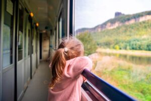 Niña mirando por la ventana en un tren