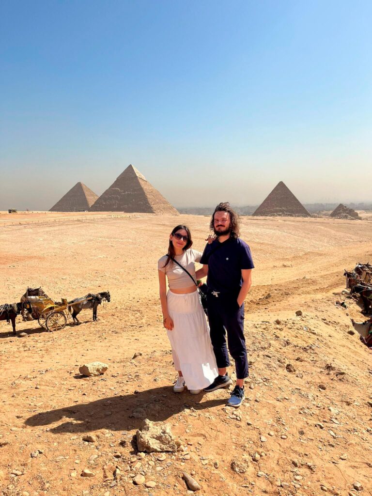 Pareja disfrutando de su viaje a Egipto visitando las Pirámides de Giza